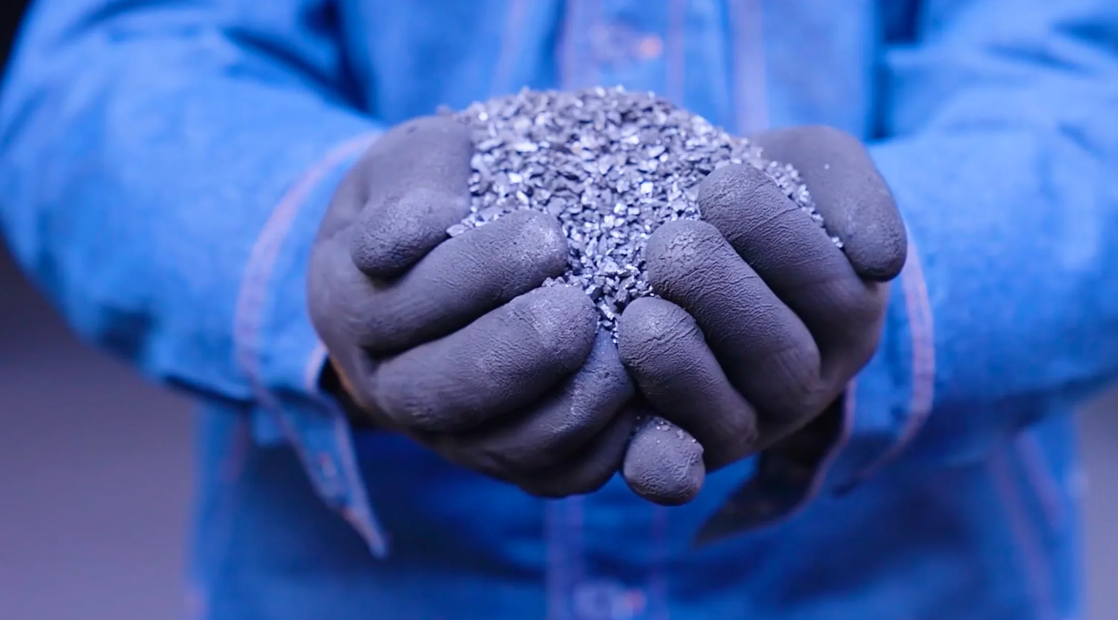 Gloved hands presenting calcined anthracite coal granules